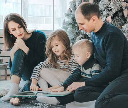 family reading book together during Christmas