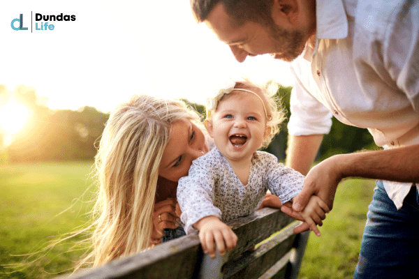 Happy couple playing with daughter at a park.